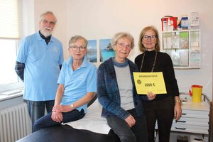 Vier Personen mit einem symbolischen Scheck 